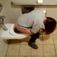 A girl is secretly recorded by her friend as she pisses into a toilet at a public restroom.